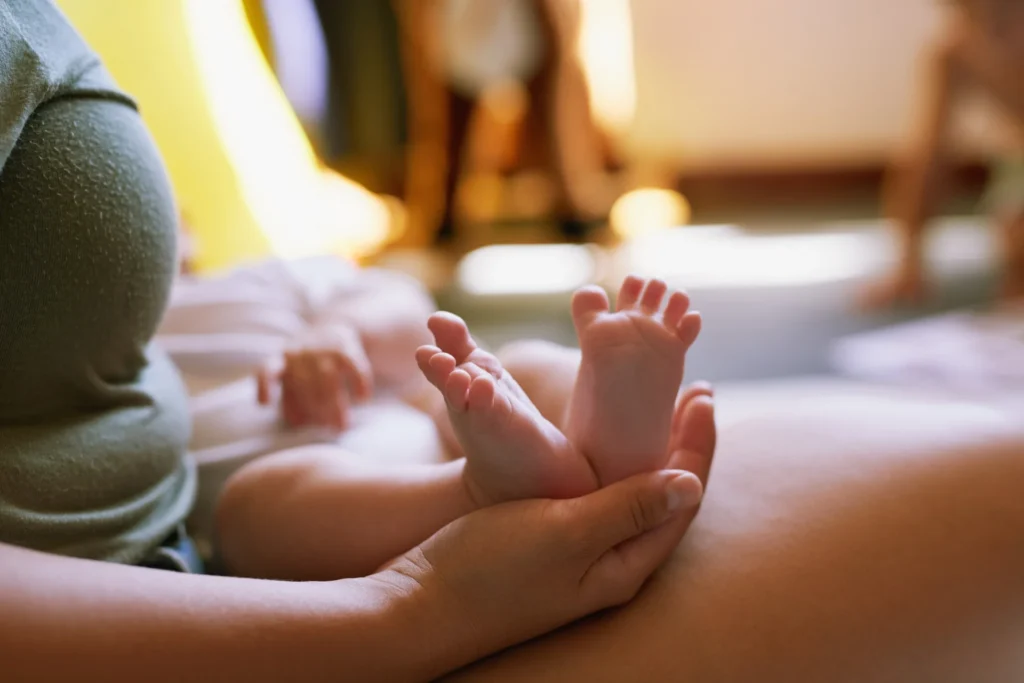 infant s tiny feet held gently in hand
